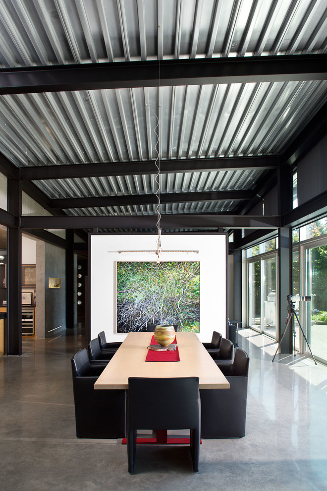 This is an example of a large contemporary open plan dining in Vancouver with white walls and concrete floors.
