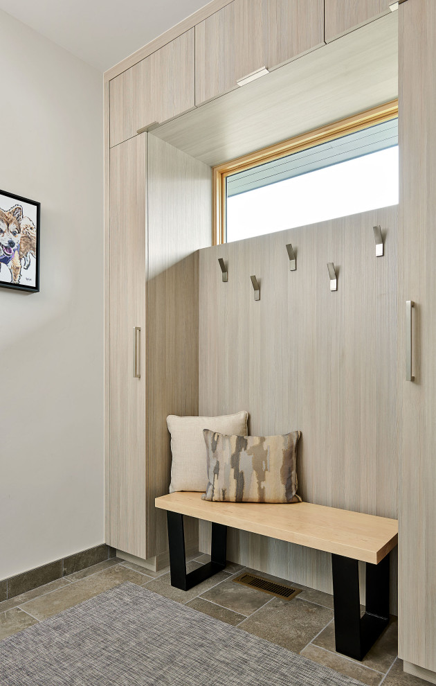 Example of a minimalist built-in closet design in Other with flat-panel cabinets and light wood cabinets