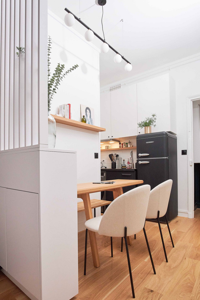 Diseño de comedor minimalista pequeño abierto con paredes blancas, suelo de madera clara y papel pintado