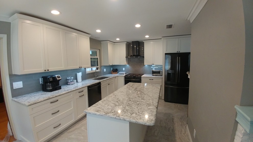 Design ideas for a mid-sized midcentury l-shaped eat-in kitchen in Tampa with an undermount sink, shaker cabinets, white cabinets, quartz benchtops, grey splashback, subway tile splashback, black appliances, with island and grey floor.