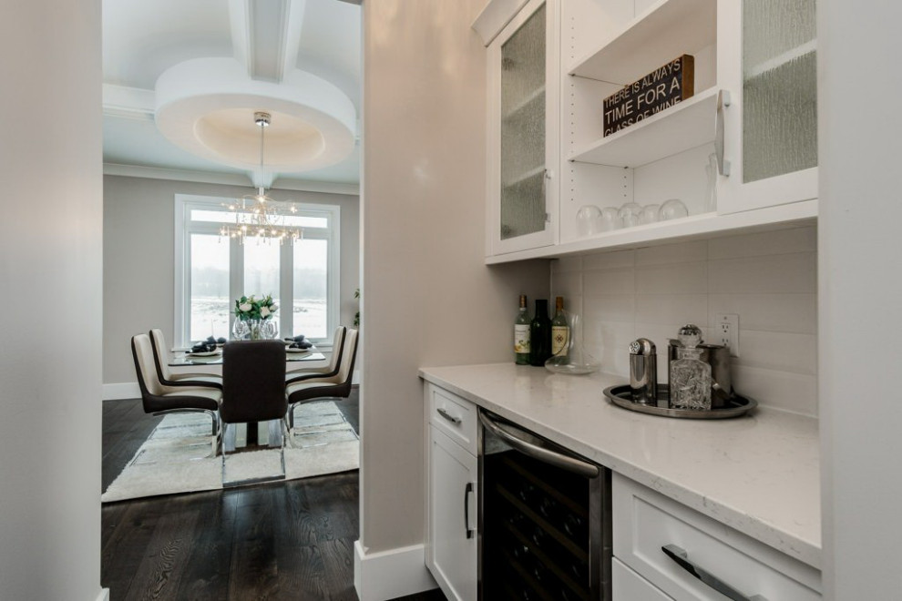 Example of a mid-sized transitional l-shaped dark wood floor and brown floor open concept kitchen design in Ottawa with an undermount sink, shaker cabinets, white cabinets, quartz countertops, white backsplash, subway tile backsplash, stainless steel appliances, an island and white countertops