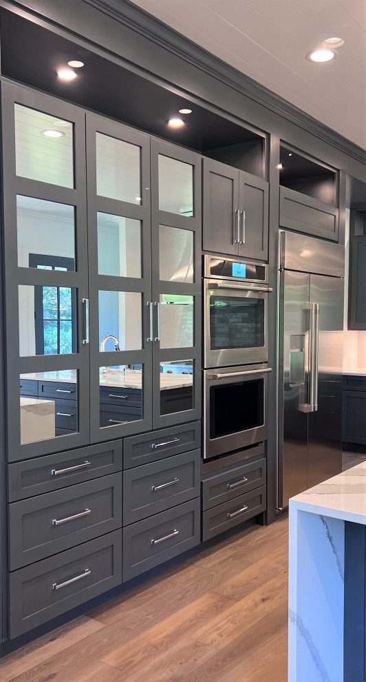 Inspiration for a large transitional kitchen remodel with an undermount sink, shaker cabinets, gray cabinets, quartz countertops, white backsplash, stainless steel appliances, two islands and white countertops