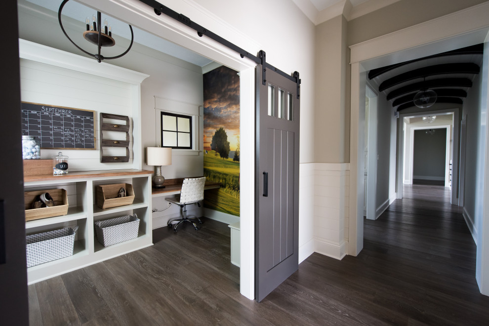 Inspiration for a mid-sized contemporary craft room in Indianapolis with multi-coloured walls, dark hardwood floors, no fireplace, a built-in desk and grey floor.