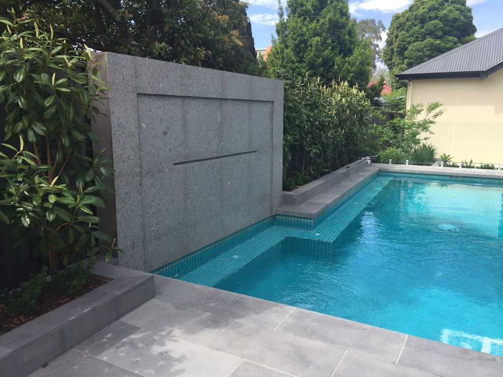 Foto de piscina con fuente contemporánea pequeña rectangular en patio con adoquines de piedra natural