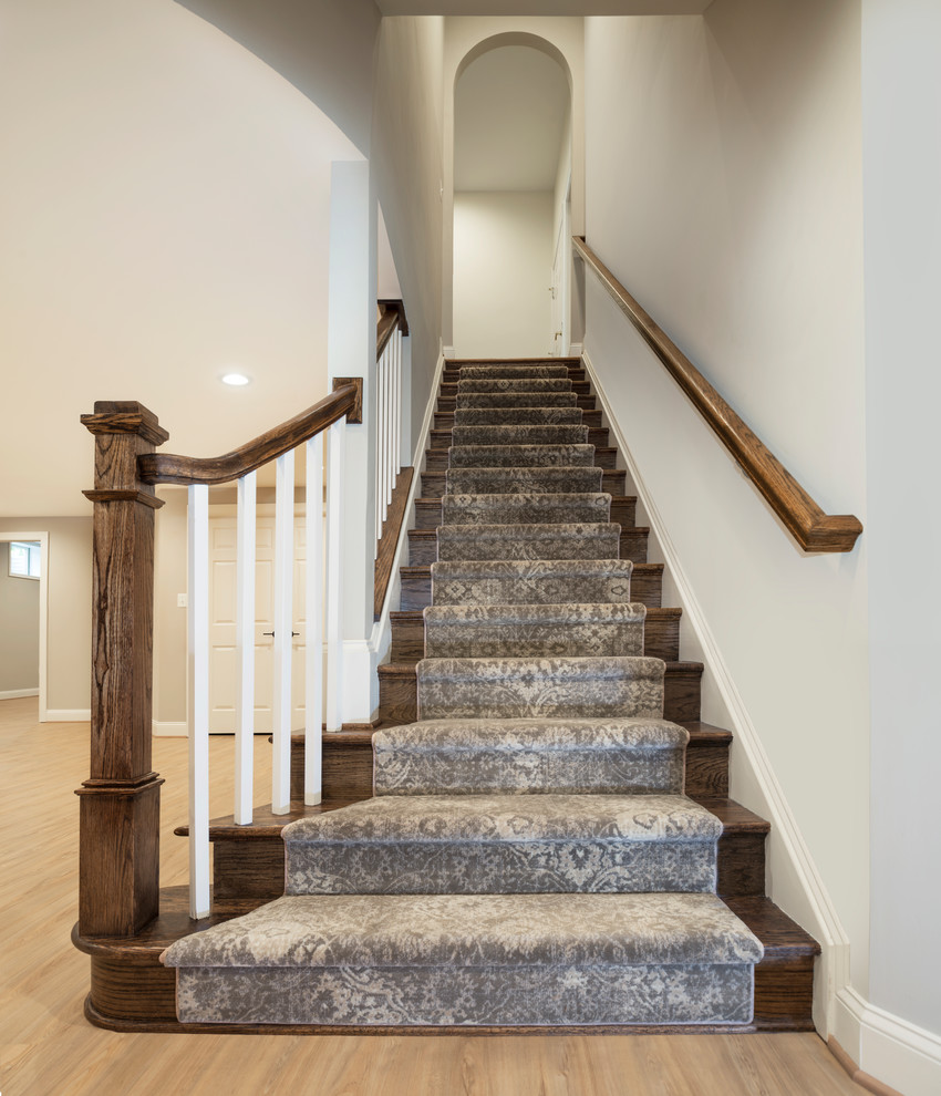 Inspiration for a transitional walk-out vinyl floor and beige floor staircase remodel in DC Metro with beige walls, a standard fireplace and a stone fireplace