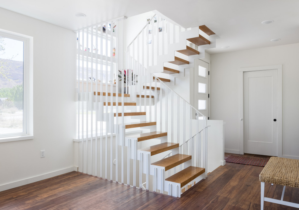 Стильный дизайн: п-образная лестница среднего размера в стиле фьюжн с деревянными ступенями и металлическими перилами без подступенок - последний тренд