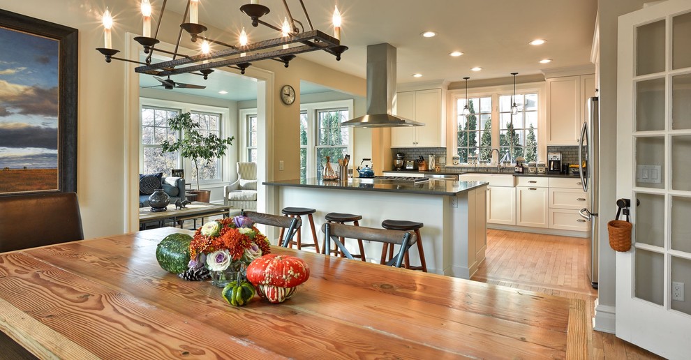 This is an example of a mid-sized traditional kitchen/dining combo in Other with light hardwood floors and grey walls.