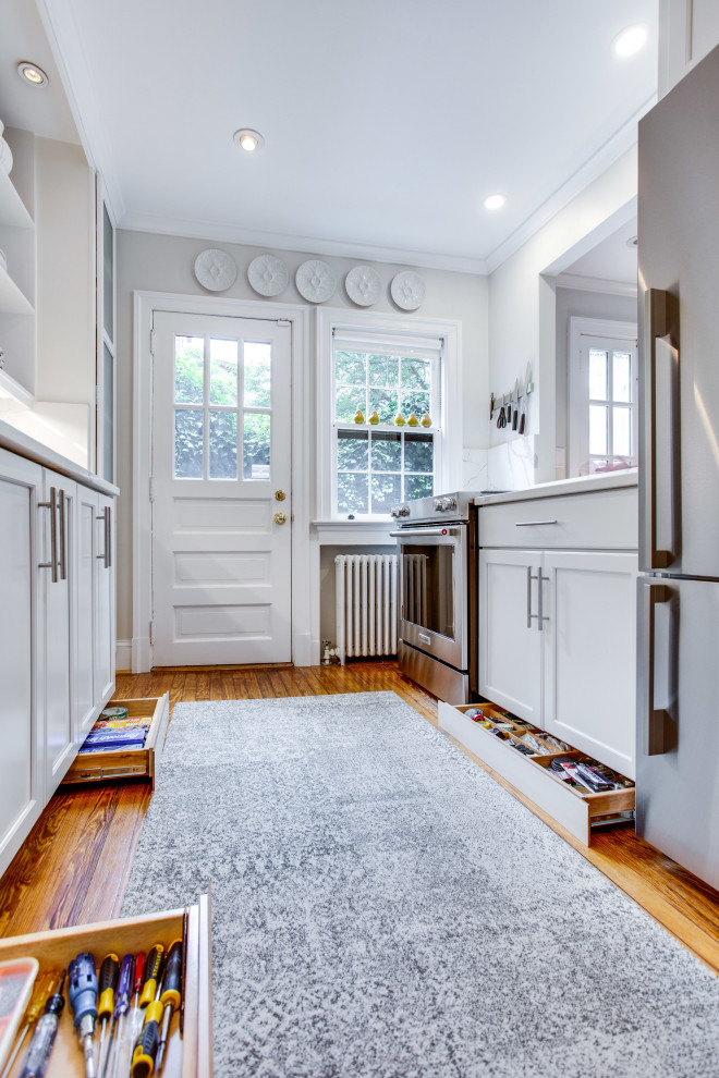 Inspiration for a small transitional galley separate kitchen in DC Metro with an undermount sink, recessed-panel cabinets, quartz benchtops, engineered quartz splashback, medium hardwood floors and no island.