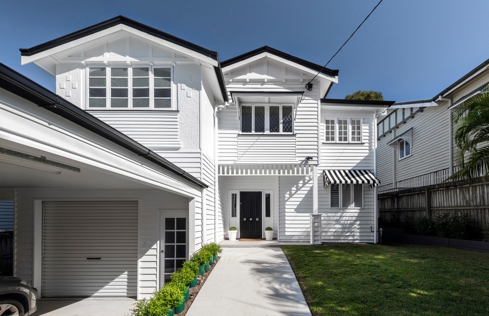 Country two-storey white house exterior in Brisbane with a gable roof, vinyl siding and a metal roof.