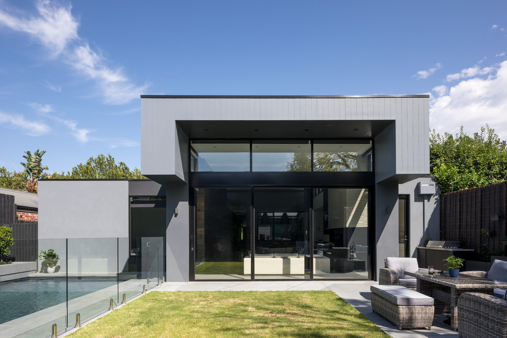 Large contemporary one-storey grey house exterior in Melbourne with mixed siding and a flat roof.