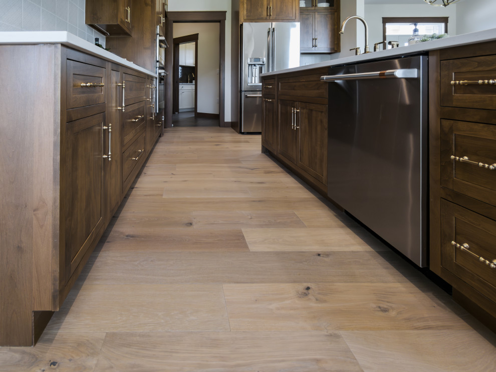 Inspiration for a transitional galley light wood floor and beige floor open concept kitchen remodel with shaker cabinets, medium tone wood cabinets, quartz countertops, white backsplash, porcelain backsplash, stainless steel appliances, an island and white countertops