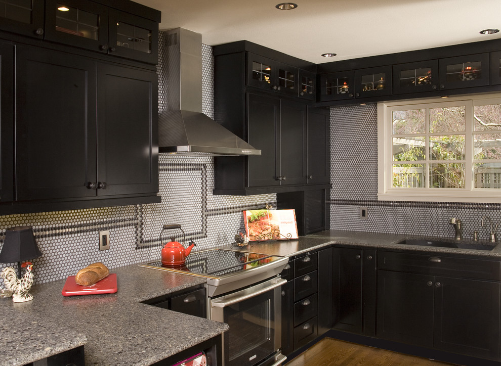 Small traditional u-shaped eat-in kitchen in Seattle with shaker cabinets, a peninsula, black cabinets, quartzite benchtops, an undermount sink, multi-coloured splashback, mosaic tile splashback, stainless steel appliances and medium hardwood floors.