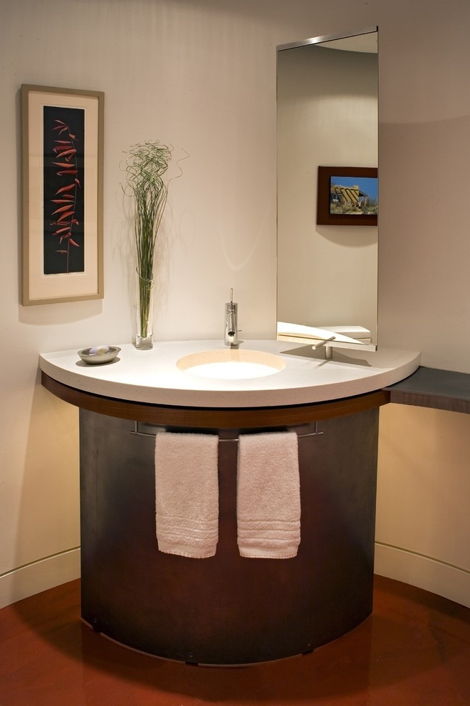 Photo of a small contemporary powder room in Minneapolis with a one-piece toilet, white walls, concrete floors, solid surface benchtops and an undermount sink.