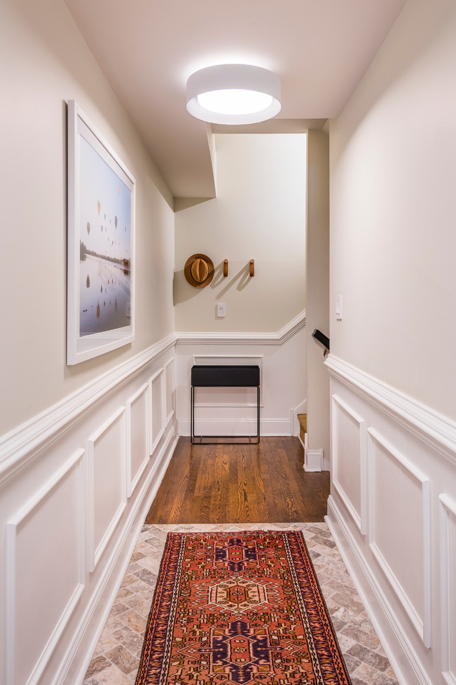 Inspiration for a small transitional entry hall in Philadelphia with white walls, limestone floors, a single front door and brown floor.