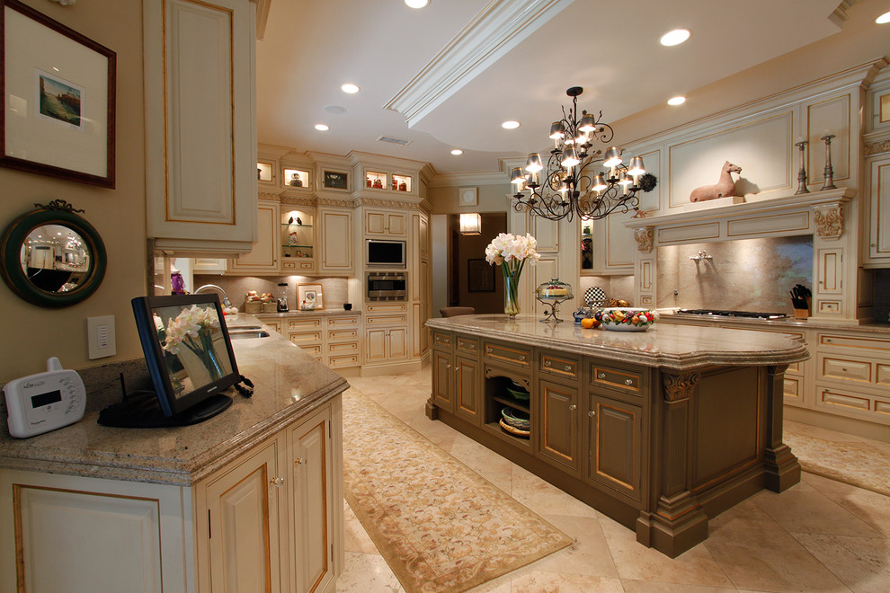 Photo of a traditional u-shaped kitchen in San Diego with marble benchtops, raised-panel cabinets and beige cabinets.