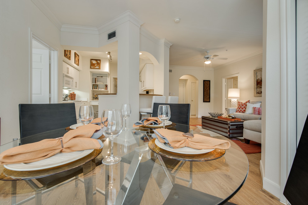 Example of a small transitional laminate floor and brown floor enclosed dining room design in Houston with white walls