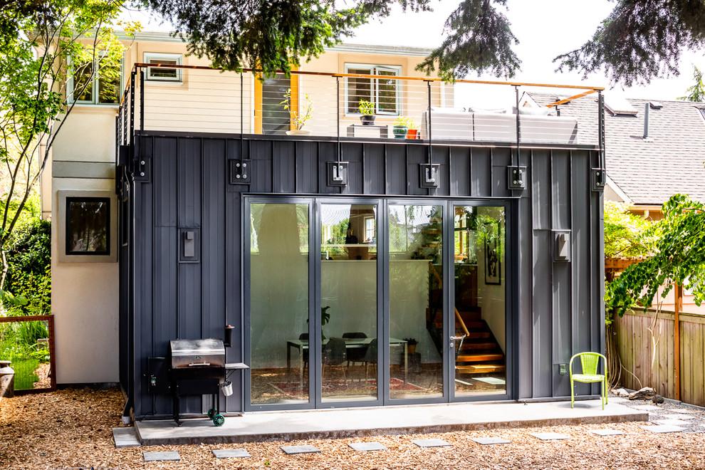 Small modern one-storey grey house exterior in Seattle with metal siding and a flat roof.
