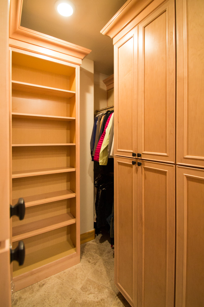 Design ideas for a large traditional gender-neutral walk-in wardrobe in Denver with raised-panel cabinets, light wood cabinets, travertine floors and beige floor.