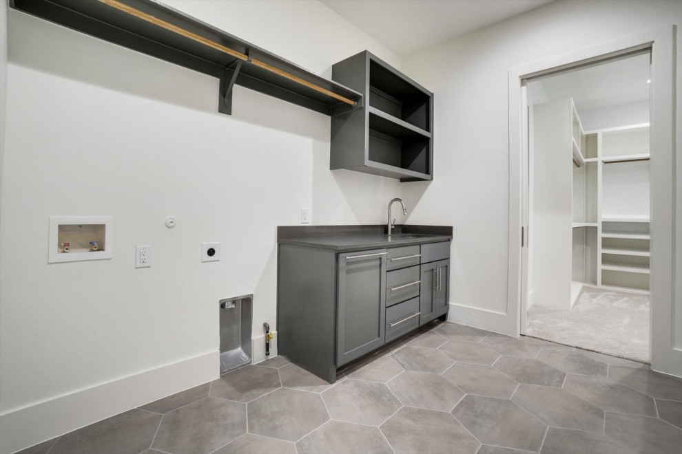 This is an example of a medium sized l-shaped separated utility room in Dallas with a submerged sink, shaker cabinets, grey cabinets, composite countertops, black splashback, ceramic splashback, white walls, ceramic flooring, a side by side washer and dryer, multi-coloured floors and black worktops.