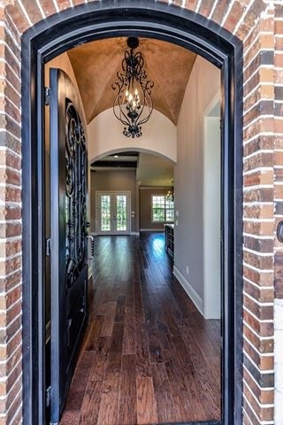 Large country foyer in Austin with beige walls, dark hardwood floors, a single front door and a black front door.