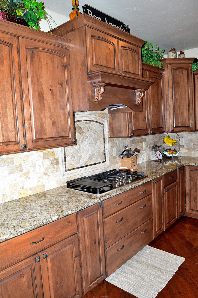 Kitchen - rustic kitchen idea in Denver with an undermount sink, granite countertops, beige backsplash, stone tile backsplash and an island