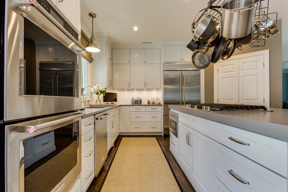 Inspiration for a mid-sized transitional l-shaped kitchen in DC Metro with an undermount sink, shaker cabinets, white cabinets, quartz benchtops, white splashback, subway tile splashback, stainless steel appliances, medium hardwood floors and with island.
