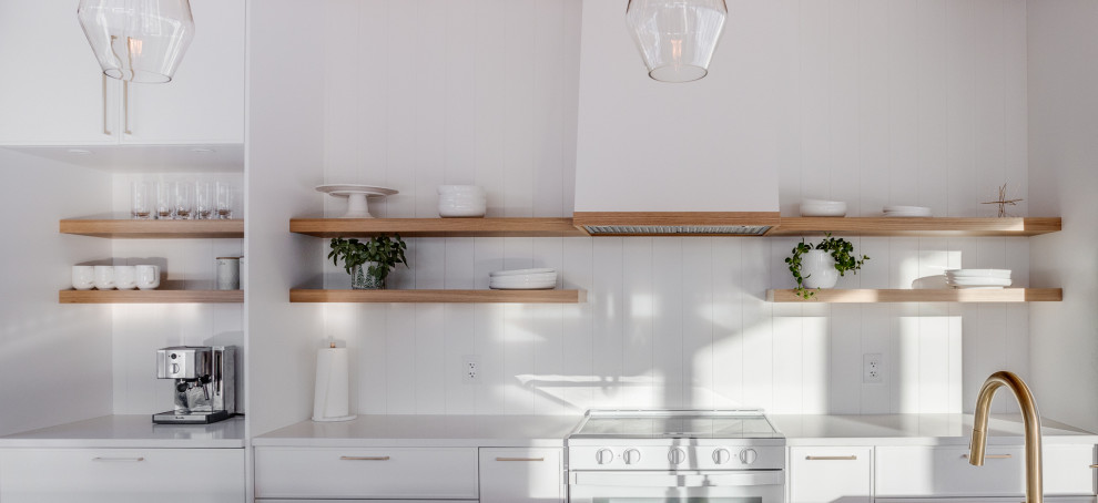 Foto di una cucina nordica con lavello sottopiano, ante lisce, ante bianche, paraspruzzi bianco, paraspruzzi in perlinato, pavimento in cemento e soffitto in legno