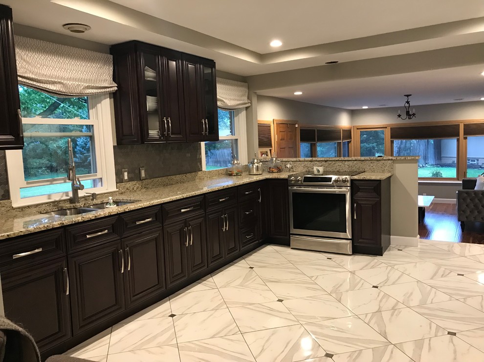 Photo of a mid-sized transitional l-shaped separate kitchen in Detroit with an undermount sink, raised-panel cabinets, black cabinets, granite benchtops, grey splashback, ceramic splashback, stainless steel appliances, marble floors, no island, white floor and multi-coloured benchtop.