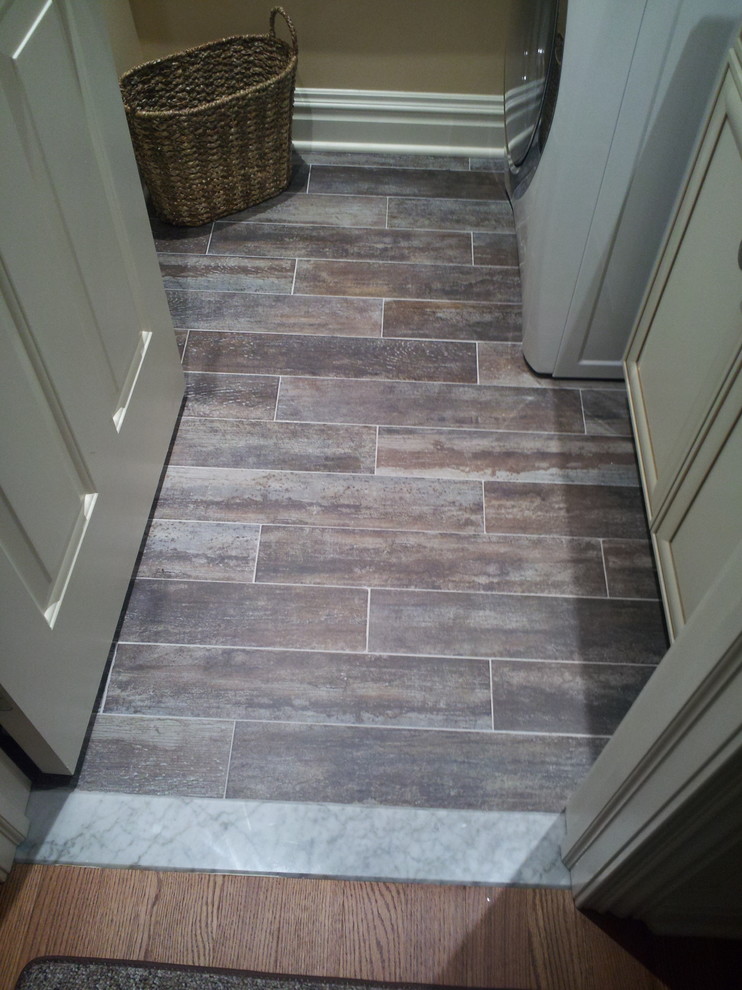 Example of a small mountain style single-wall medium tone wood floor home design design in New York with raised-panel cabinets, white cabinets, beige walls and a stacked washer/dryer