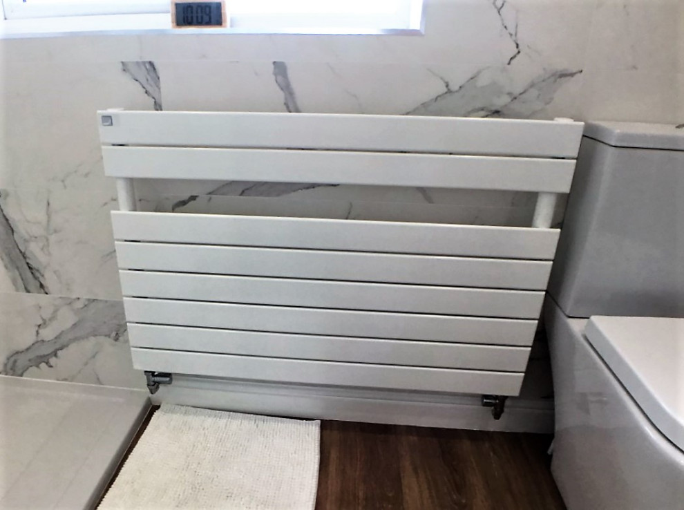 Modelo de cuarto de baño principal, único y flotante de tamaño medio con armarios con paneles lisos, puertas de armario de madera oscura, ducha abierta y ducha abierta
