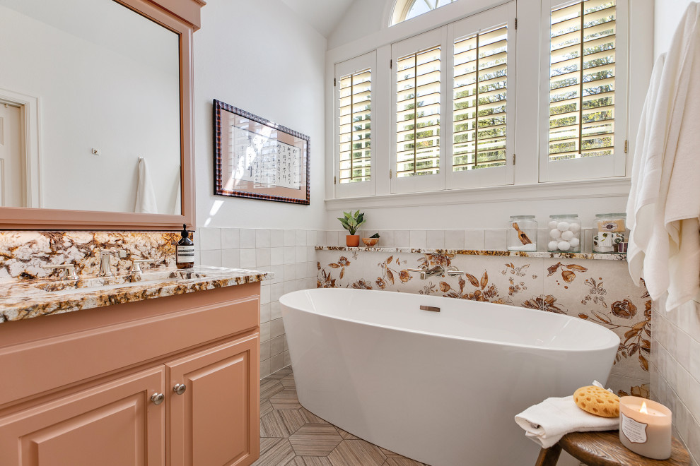 Пример оригинального дизайна: большая главная ванная комната в стиле фьюжн с фасадами с выступающей филенкой, коричневыми фасадами, отдельно стоящей ванной, душем в нише, унитазом-моноблоком, разноцветной плиткой, керамической плиткой, белыми стенами, полом из керамогранита, накладной раковиной, столешницей из гранита, серым полом, душем с распашными дверями, разноцветной столешницей, нишей, тумбой под две раковины, встроенной тумбой и сводчатым потолком