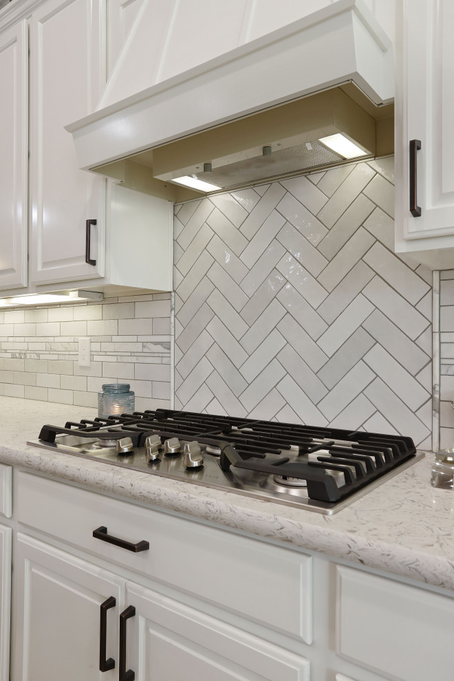Modern inredning av ett grå grått kök, med en undermonterad diskho, vita skåp, bänkskiva i kvarts, vitt stänkskydd, stänkskydd i keramik, rostfria vitvaror och en köksö