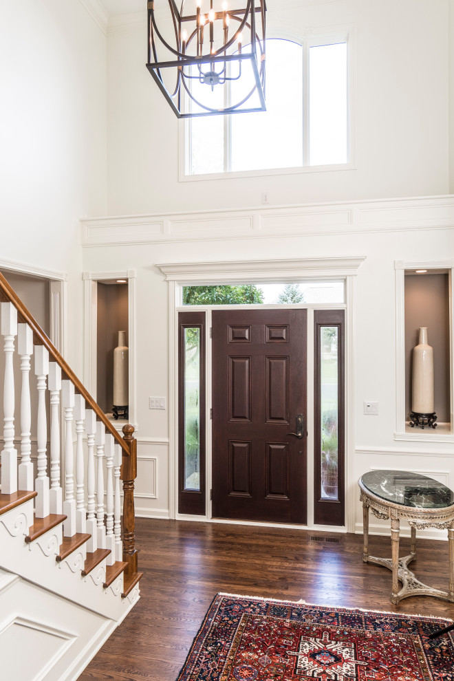 Photo of a mid-sized transitional foyer in Indianapolis with white walls, a single front door and a medium wood front door.