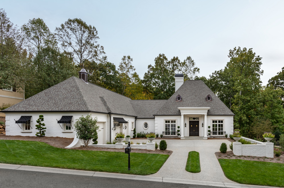 Large transitional white two-story brick house exterior photo with a hip roof and a shingle roof