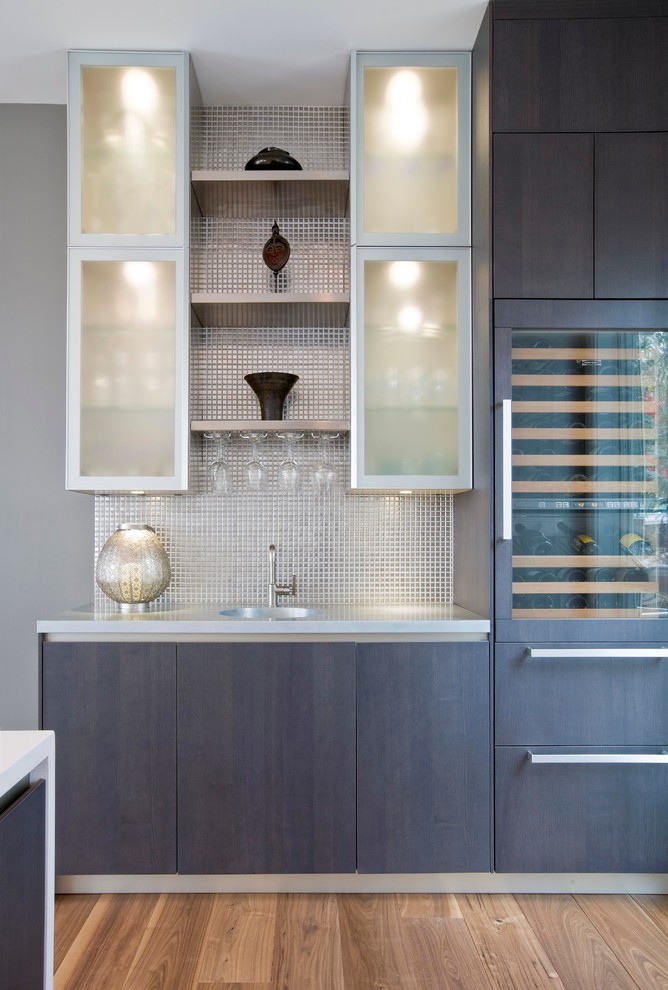 This is an example of a contemporary single-wall wet bar in Miami with flat-panel cabinets, dark wood cabinets, grey splashback, mosaic tile splashback and dark hardwood floors.