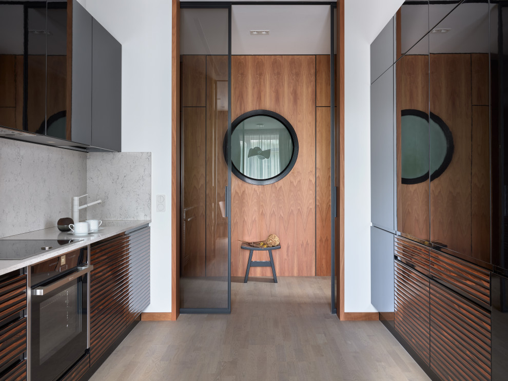 Идея дизайна: кухня среднего размера в современном стиле с монолитной мойкой, черными фасадами, серым фартуком и серой столешницей без острова