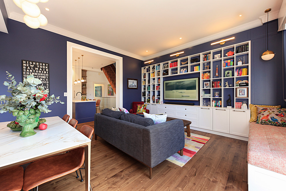 Idées déco pour une salle de séjour classique de taille moyenne et ouverte avec un mur bleu, un sol en bois brun, un téléviseur encastré et un sol marron.