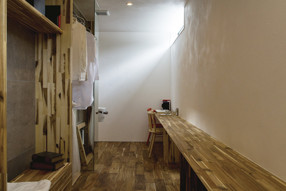 Cette image montre un dressing room asiatique en bois brun neutre avec un placard sans porte, un sol en bois brun, un sol marron et un plafond en lambris de bois.