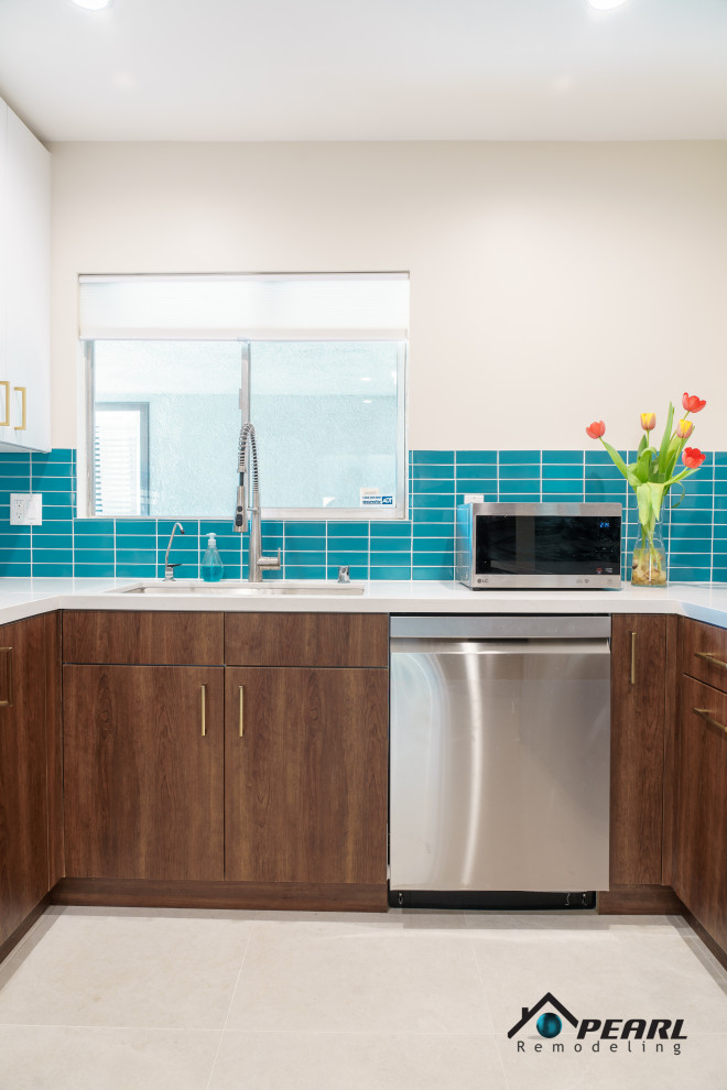 Photo of a large midcentury u-shaped kitchen pantry in Los Angeles with a drop-in sink, flat-panel cabinets, dark wood cabinets, quartzite benchtops, blue splashback, subway tile splashback, stainless steel appliances, ceramic floors, a peninsula, beige floor and white benchtop.