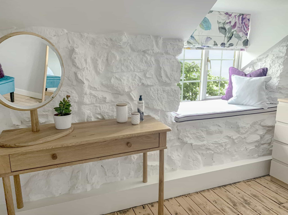 Cette image montre une chambre parentale design de taille moyenne avec un mur gris, parquet clair, un sol marron et un mur en parement de brique.