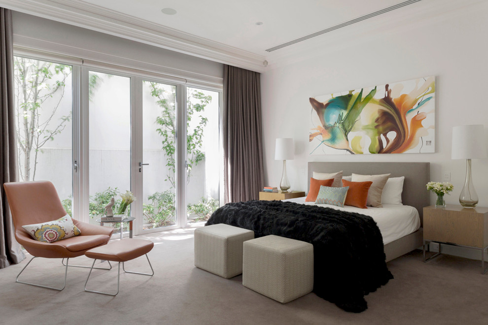 This is an example of a large contemporary master bedroom in Melbourne with white walls, carpet, no fireplace and beige floor.
