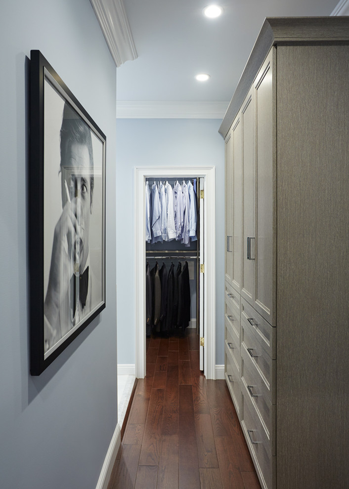 Design ideas for a mid-sized transitional women's walk-in wardrobe in New York with recessed-panel cabinets, grey cabinets and medium hardwood floors.