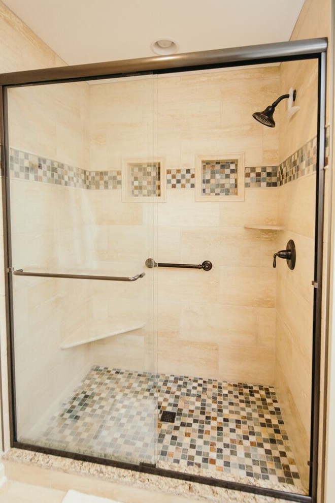 This is an example of a mid-sized traditional master bathroom in Indianapolis with beaded inset cabinets, medium wood cabinets, a drop-in tub, an alcove shower, beige walls, mosaic tile floors, an undermount sink and granite benchtops.
