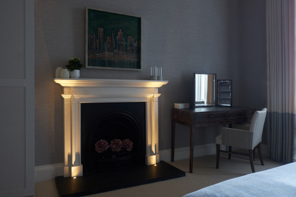 Photo of a transitional bedroom in Edinburgh with a standard fireplace and a stone fireplace surround.