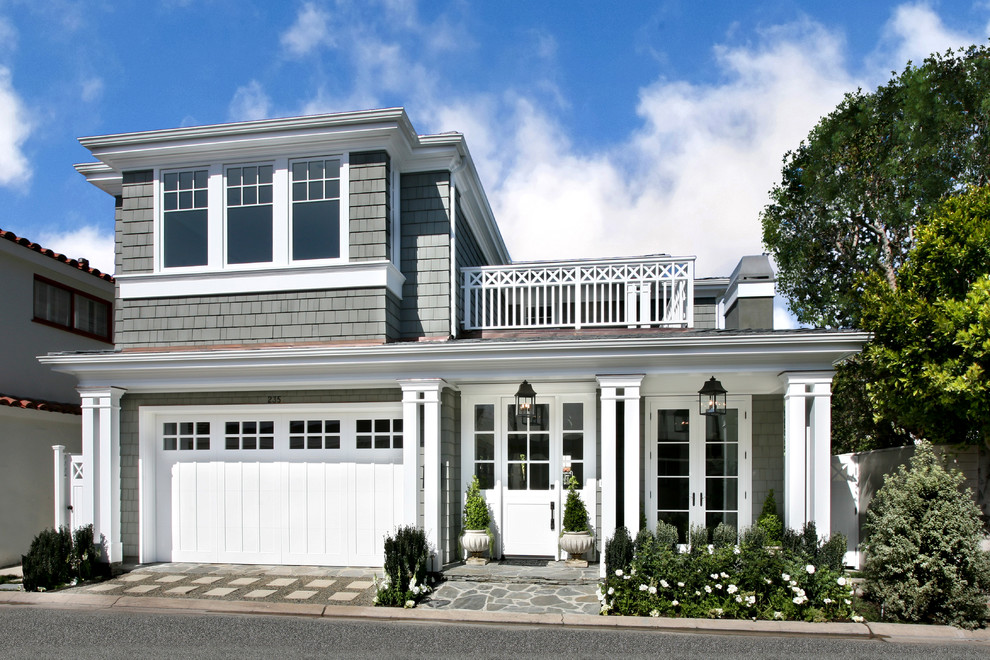 This is an example of a beach style two-storey grey exterior in Orange County with wood siding.