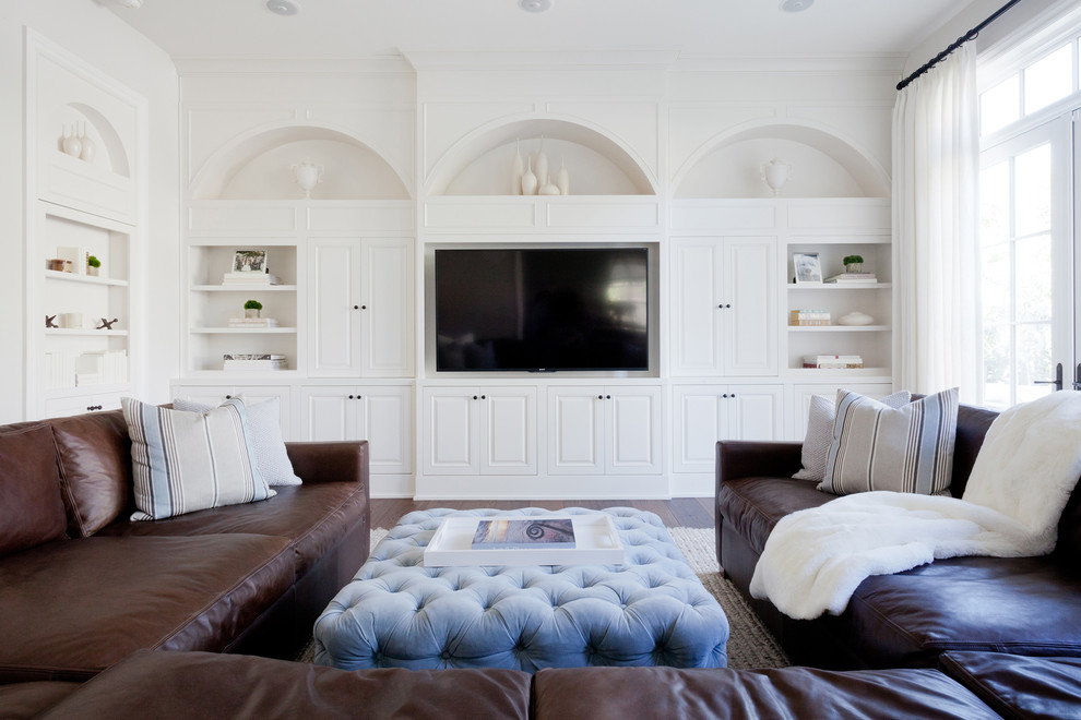 This is an example of an expansive transitional family room in Los Angeles with white walls, a built-in media wall, no fireplace and medium hardwood floors.