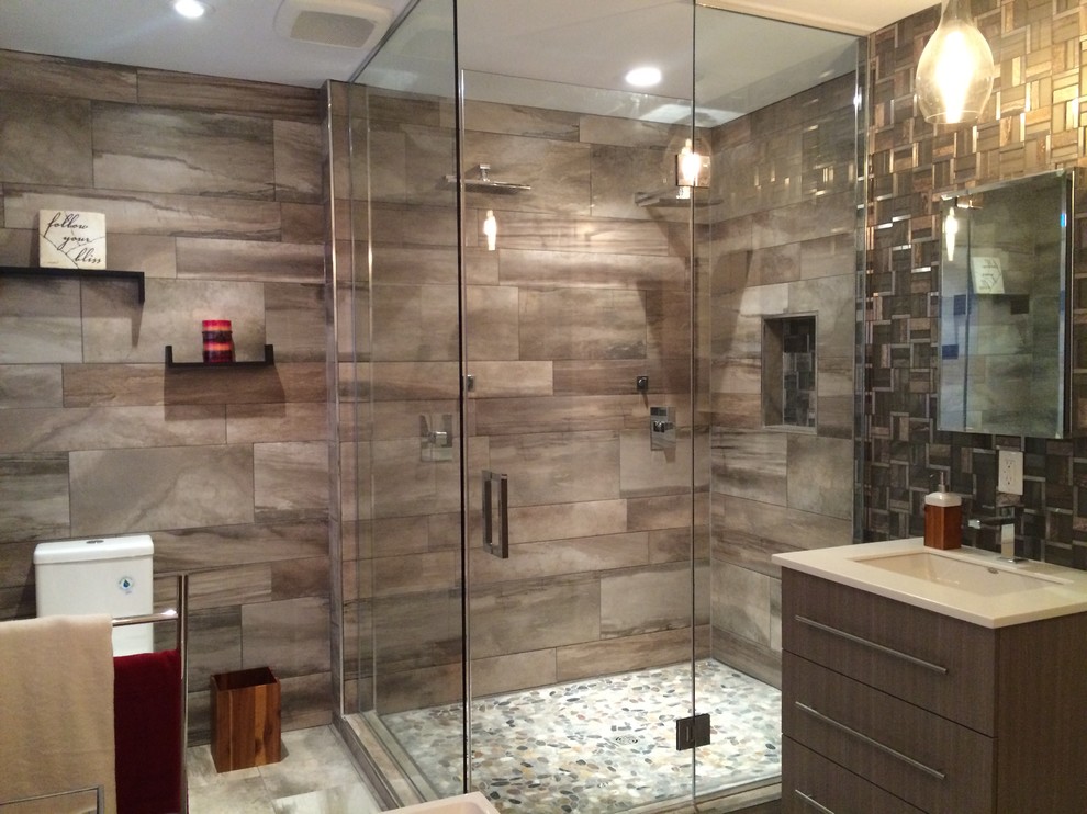 Inspiration for a large contemporary master bathroom in Other with flat-panel cabinets, dark wood cabinets, mosaic tile, solid surface benchtops, a freestanding tub, a corner shower, a one-piece toilet, brown walls, travertine floors and an undermount sink.