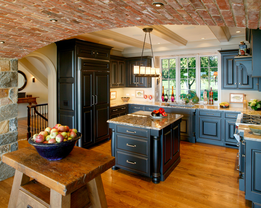 Photo of a traditional u-shaped separate kitchen in Other with an undermount sink, raised-panel cabinets, black cabinets and panelled appliances.