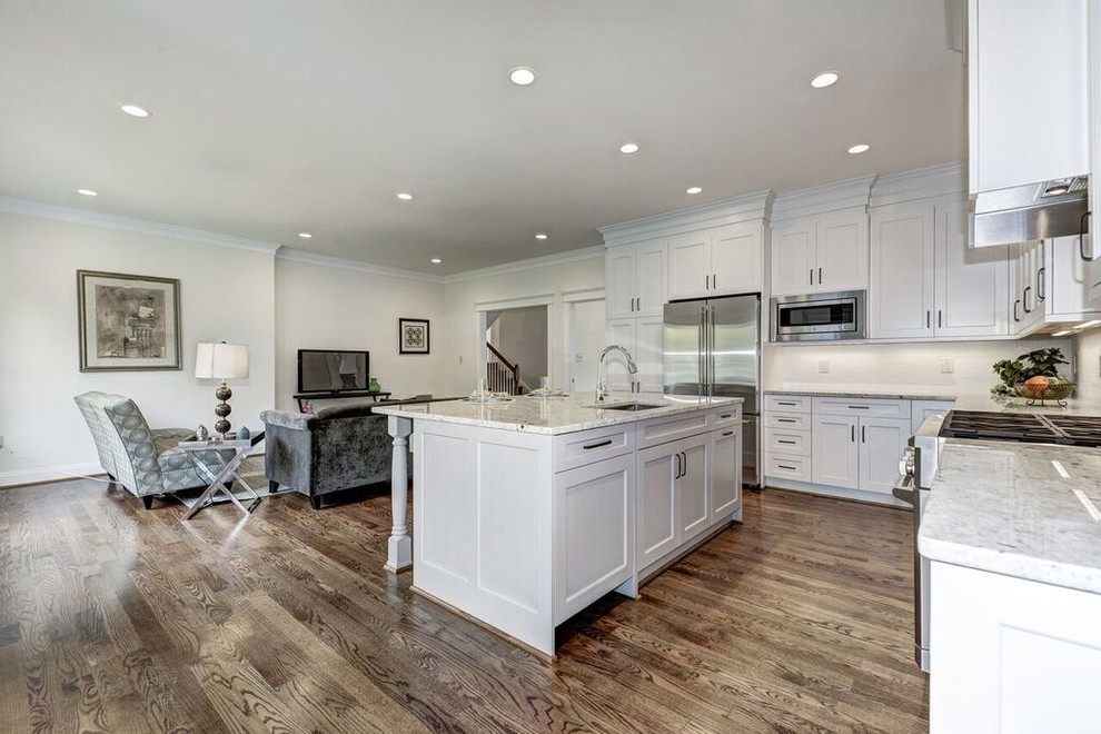 Example of a large transitional l-shaped medium tone wood floor eat-in kitchen design in DC Metro with a drop-in sink, beaded inset cabinets, white cabinets, granite countertops, white backsplash, stainless steel appliances and an island