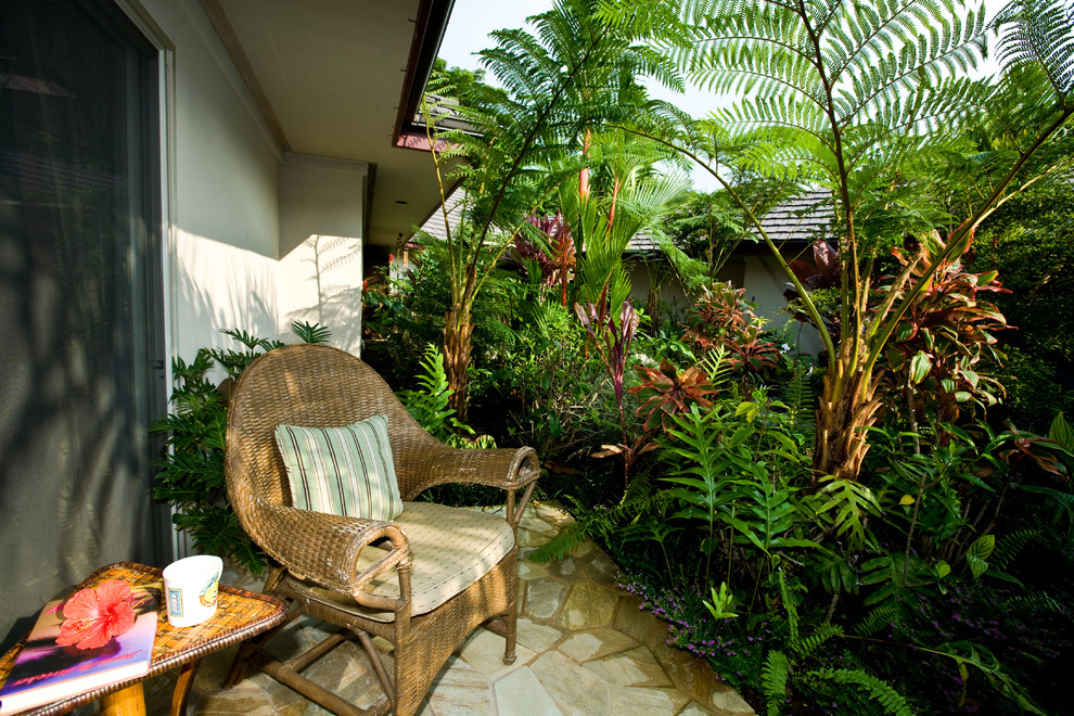 Inspiration for a mid-sized transitional side yard verandah in Hawaii with natural stone pavers and a roof extension.